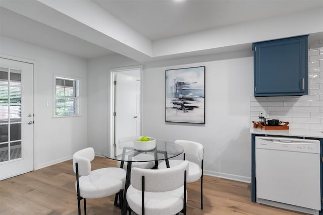 dining space with light wood finished floors and baseboards
