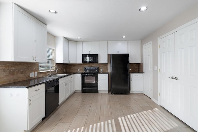 kitchen with tasteful backsplash, recessed lighting, black appliances, a sink, and white cabinetry