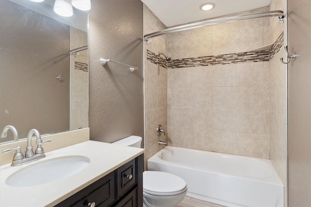bathroom with shower / bathing tub combination, vanity, toilet, and a textured wall