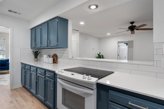 kitchen with decorative backsplash, white range with electric stovetop, blue cabinetry, a ceiling fan, and visible vents