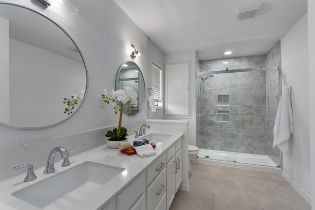 full bath with toilet, double vanity, a sink, and a shower stall