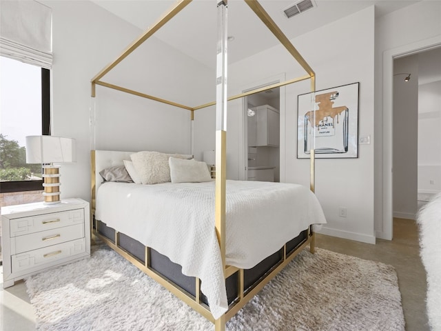 bedroom with concrete floors, visible vents, baseboards, and a closet