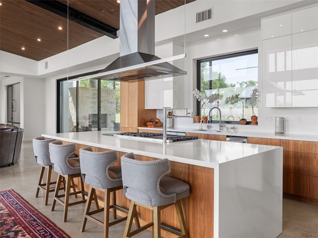 kitchen with a sink, modern cabinets, wooden ceiling, wall chimney exhaust hood, and visible vents
