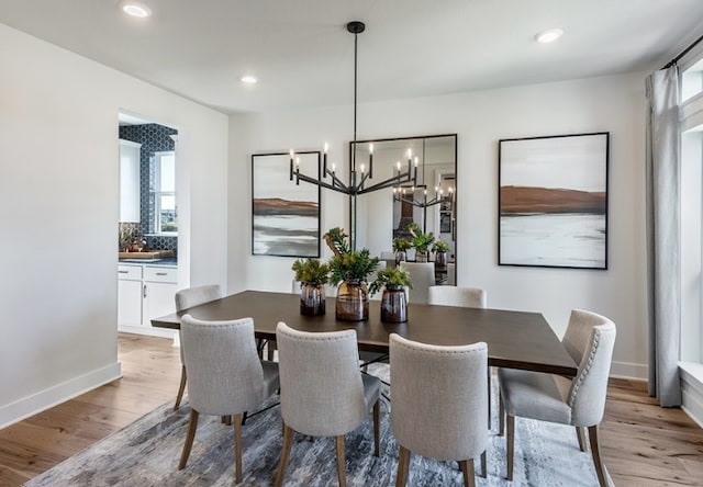 dining area featuring recessed lighting, an inviting chandelier, baseboards, and light wood-type flooring