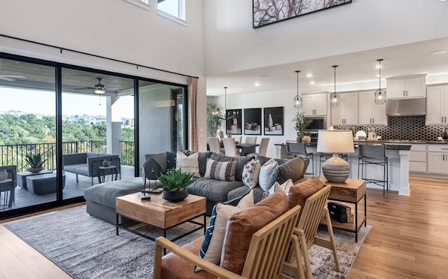 living room featuring ceiling fan, light wood-type flooring, and recessed lighting