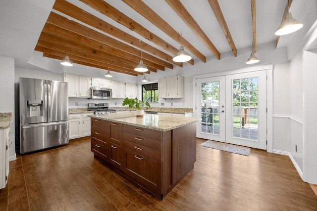 11811 Buggy Whip Trl, Austin, TX 78750 - kitchen featuring appliances with stainless steel finishes, beam ceiling, white cabinets, dark wood-type flooring, and a kitchen island