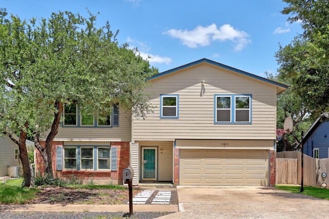 11811 Buggy Whip Trl, Austin, TX 78750 - view of front of house featuring brick siding, a garage, driveway, and cooling unit
