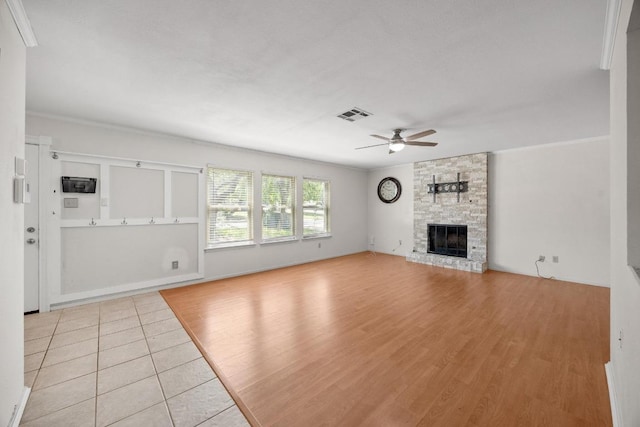 11811 Buggy Whip Trl, Austin, TX 78750 - unfurnished living room featuring a ceiling fan, a stone fireplace, and light tile patterned flooring