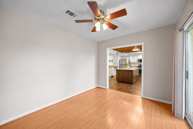 11811 Buggy Whip Trl, Austin, TX 78750 - unfurnished living room with dark wood finished floors, ceiling fan, baseboards, a textured ceiling, and plenty of natural light