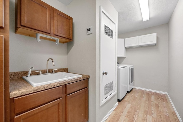 11811 Buggy Whip Trl, Austin, TX 78750 - kitchen with washer and clothes dryer, a sink, light wood-type flooring, brown cabinets, and light countertops