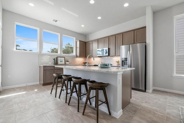 320 Creek Rd Unit 202, Dripping Springs, TX 78620 - kitchen with stainless steel appliances, a sink, light stone counters, recessed lighting, and a kitchen breakfast bar