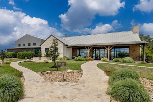 320 Creek Rd Unit 202, Dripping Springs, TX 78620 - view of front facade with a front lawn, metal roof, and a chimney