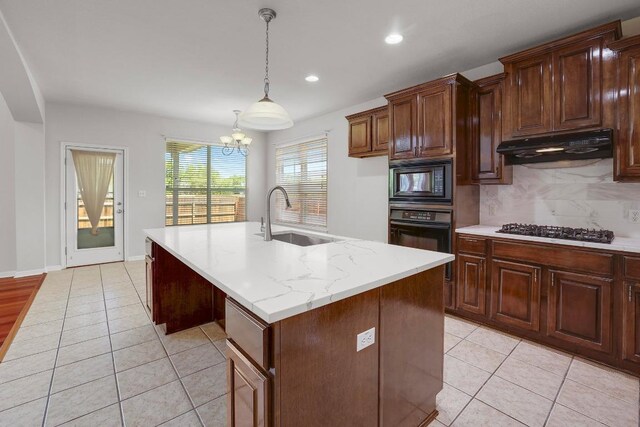 11100 Alison Parke Trl, Austin, TX 78750 - kitchen with black appliances, under cabinet range hood, a sink, an island with sink, and light tile patterned flooring