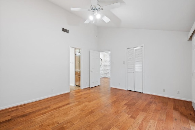 unfurnished bedroom featuring visible vents, high vaulted ceiling, light wood finished floors, and baseboards
