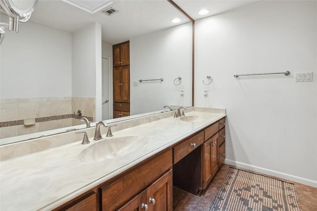bathroom featuring double vanity, visible vents, recessed lighting, and a sink