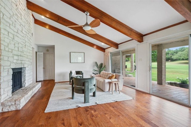 living area with baseboards, lofted ceiling with beams, a ceiling fan, and wood finished floors