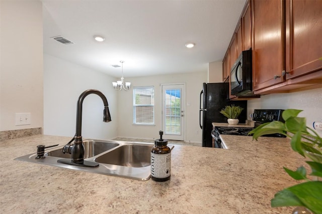 kitchen featuring light countertops, brown cabinets, black appliances, a sink, and visible vents