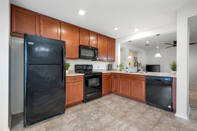 kitchen with pendant lighting, a sink, light countertops, black appliances, and brown cabinetry