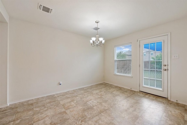 unfurnished room featuring baseboards, visible vents, and an inviting chandelier