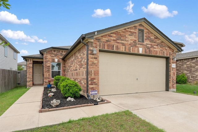 view of front of home with brick siding, driveway, an attached garage, and fence