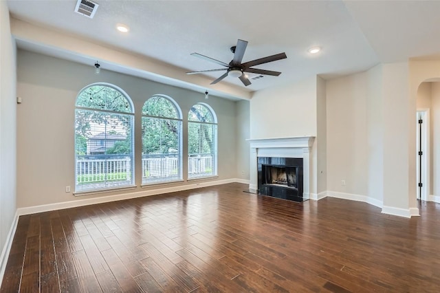 14308 Homestead Village Cir, Austin, TX 78717 - unfurnished living room featuring a ceiling fan, arched walkways, a high end fireplace, dark wood finished floors, and recessed lighting