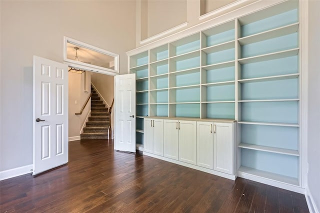 14308 Homestead Village Cir, Austin, TX 78717 - unfurnished room with dark wood-style floors, baseboards, stairs, and a towering ceiling
