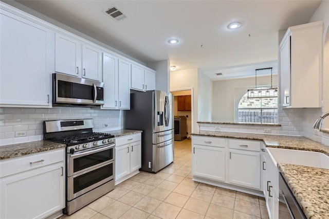 14308 Homestead Village Cir, Austin, TX 78717 - kitchen featuring stainless steel appliances, a sink, light tile patterned flooring, white cabinetry, and recessed lighting