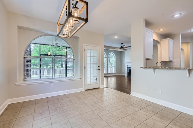 14308 Homestead Village Cir, Austin, TX 78717 - unfurnished dining area featuring ceiling fan, a fireplace, light tile patterned flooring, recessed lighting, and baseboards