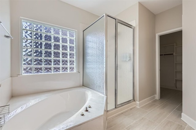14308 Homestead Village Cir, Austin, TX 78717 - full bath featuring a stall shower, a bath, a spacious closet, and tile patterned floors