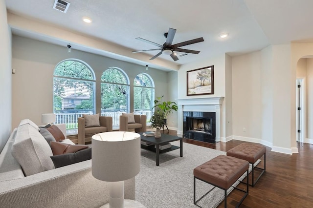 14308 Homestead Village Cir, Austin, TX 78717 - living area featuring a ceiling fan, arched walkways, baseboards, a tile fireplace, and dark wood-type flooring