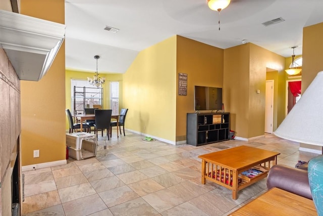 living area with lofted ceiling, visible vents, and baseboards