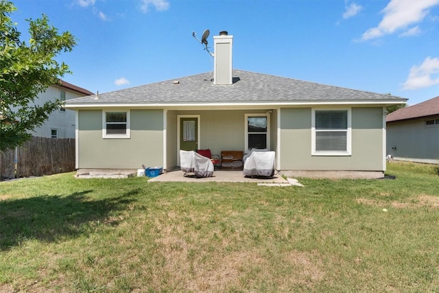 rear view of property with a patio, a chimney, a shingled roof, a lawn, and fence