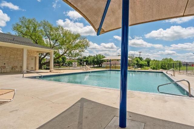 pool featuring fence and a patio area