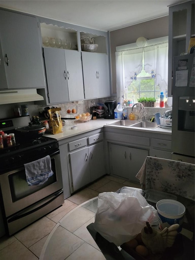 1403 Wallace St, Taylor, TX 76574 - kitchen featuring a sink, light countertops, under cabinet range hood, gas stove, and backsplash