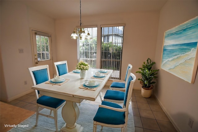 dining space with tile patterned floors, baseboards, and a chandelier