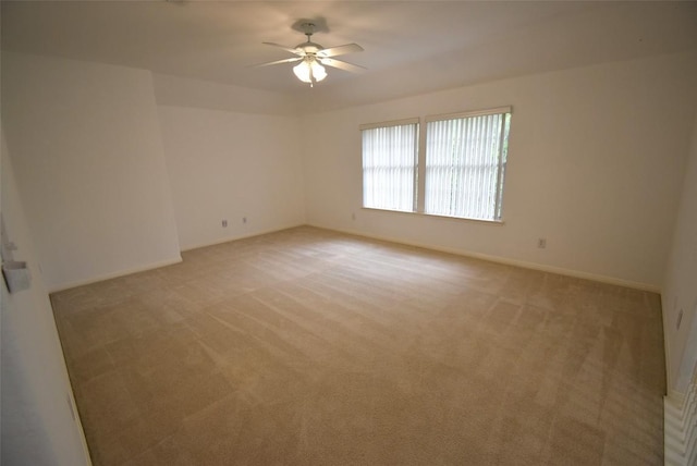 unfurnished room with ceiling fan, light carpet, and baseboards