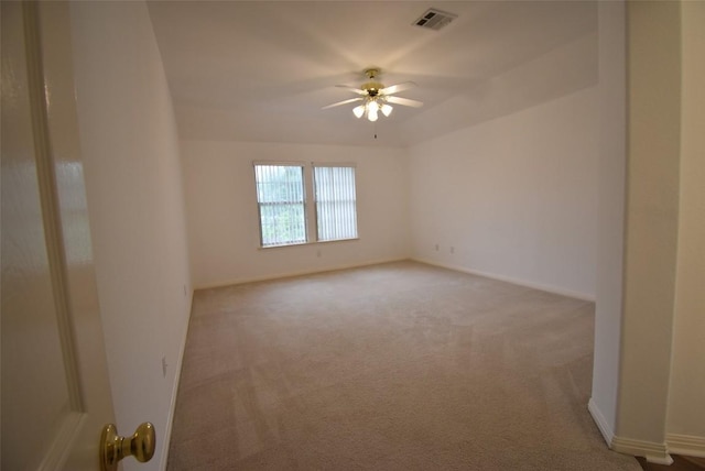 carpeted empty room with visible vents, ceiling fan, and baseboards