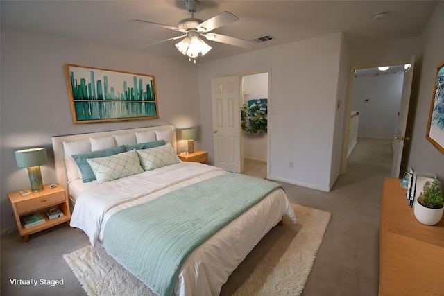 carpeted bedroom featuring baseboards, visible vents, a ceiling fan, and a walk in closet