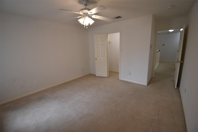 unfurnished bedroom featuring baseboards, visible vents, a walk in closet, and light colored carpet