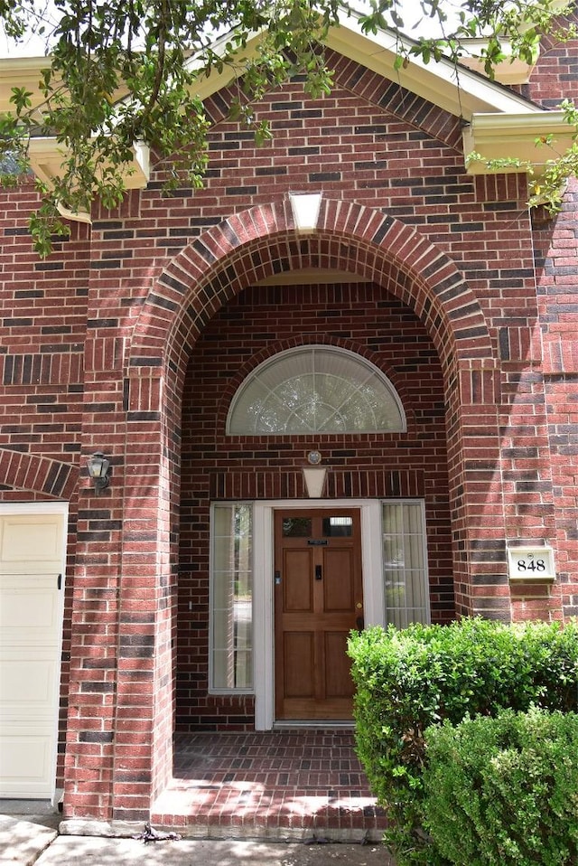 property entrance featuring brick siding