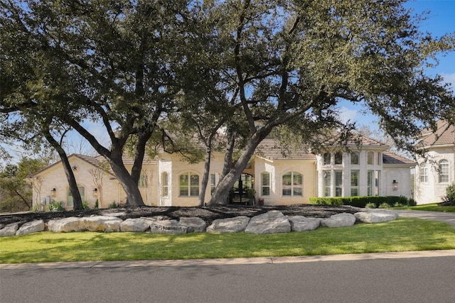 view of front facade featuring stucco siding and a front yard