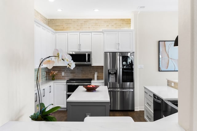 kitchen featuring ornamental molding, backsplash, white cabinets, and appliances with stainless steel finishes
