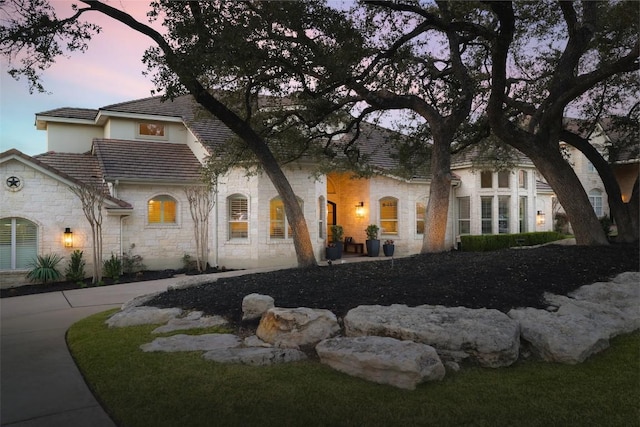 view of property exterior featuring a tile roof and stone siding