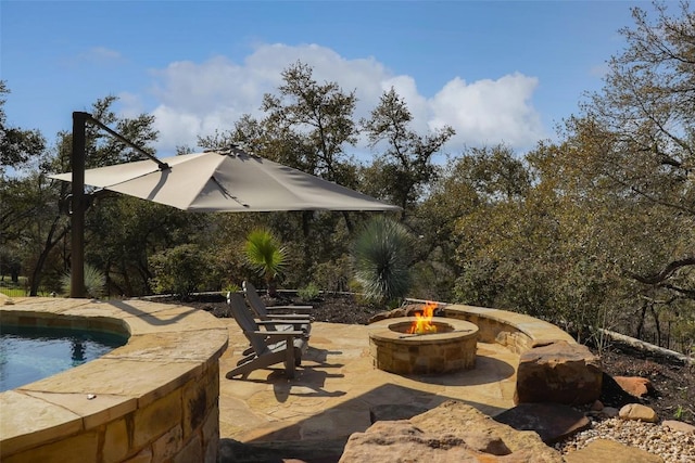 view of patio / terrace with a swimming pool and an outdoor fire pit