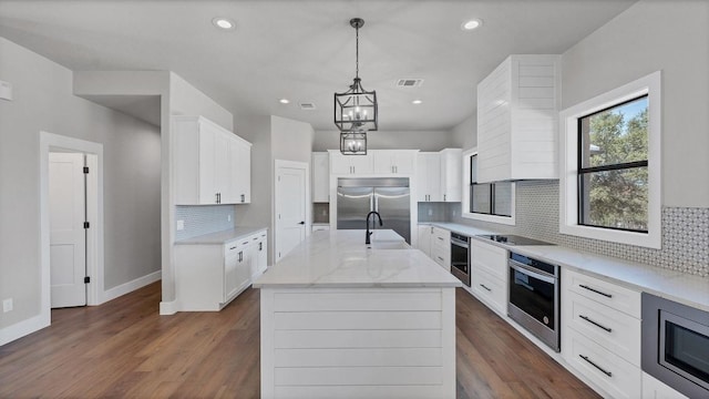 725 Winding Vw, New Braunfels, TX 78132 - kitchen featuring dark wood-style floors, built in appliances, a center island with sink, tasteful backsplash, and baseboards