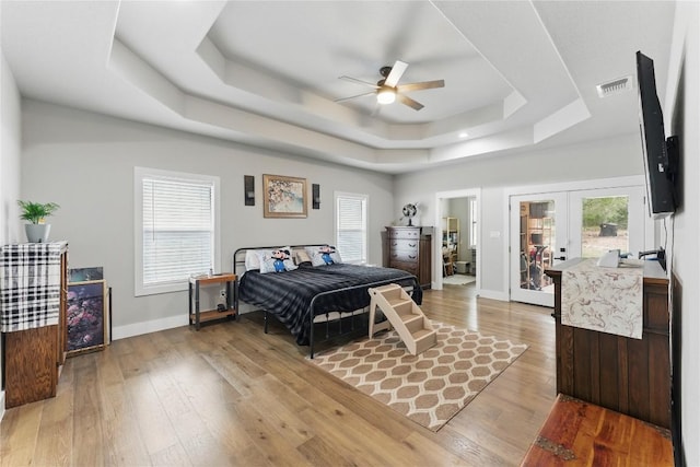725 Winding Vw, New Braunfels, TX 78132 - bedroom featuring light wood-style floors, access to exterior, baseboards, visible vents, and a tray ceiling