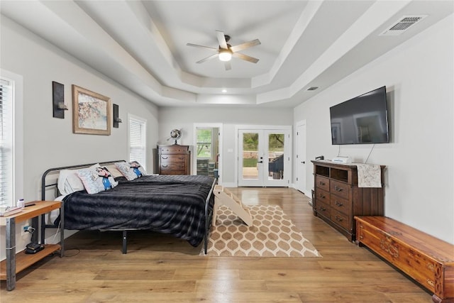 725 Winding Vw, New Braunfels, TX 78132 - bedroom featuring light wood-style flooring, visible vents, a tray ceiling, access to exterior, and french doors