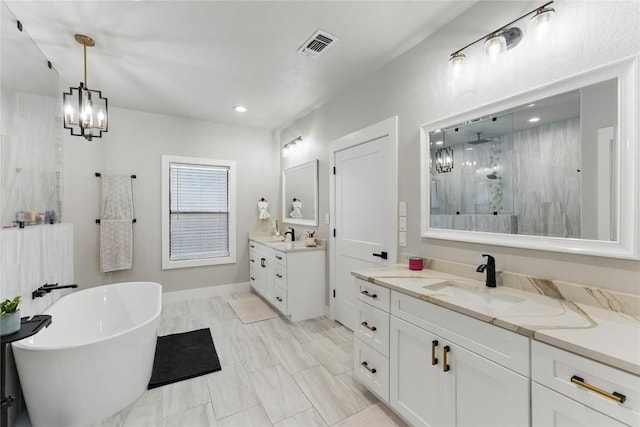 725 Winding Vw, New Braunfels, TX 78132 - bathroom with a sink, a shower stall, a notable chandelier, a freestanding bath, and visible vents