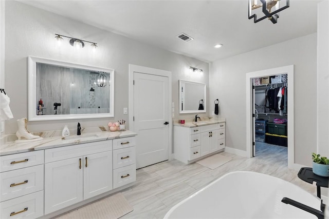 725 Winding Vw, New Braunfels, TX 78132 - bathroom featuring two vanities, a sink, a freestanding bath, and visible vents
