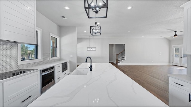 725 Winding Vw, New Braunfels, TX 78132 - kitchen featuring pendant lighting, white cabinetry, a sink, stainless steel appliances, and wood finished floors
